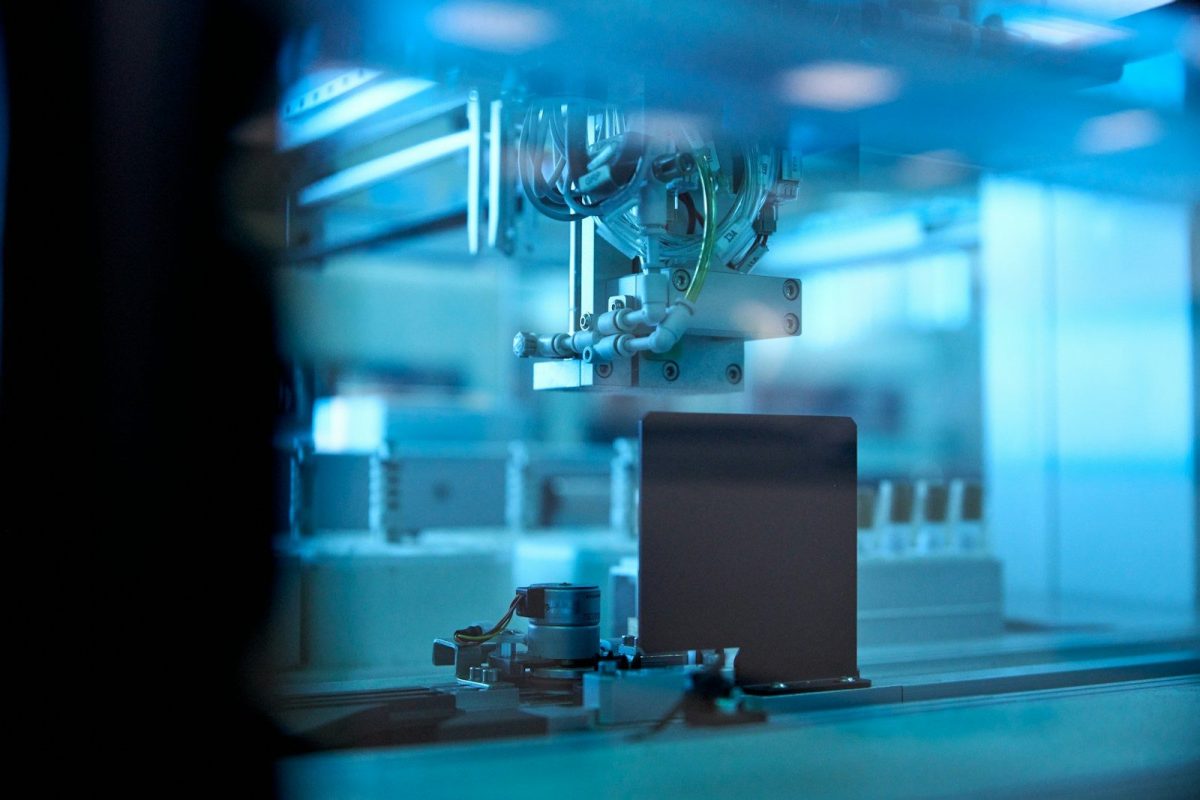 industrial robotic arm in blue lit factory