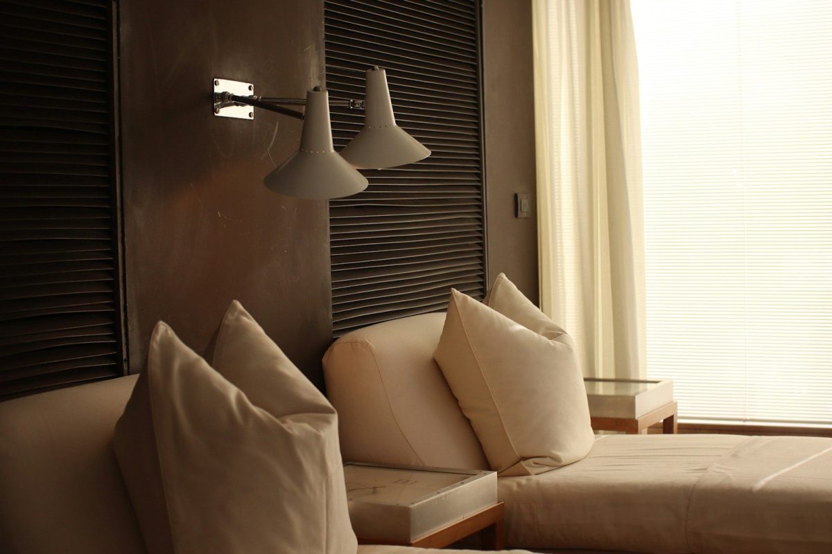a bed room with a neatly made bed next to a window